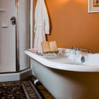 Book tray on bathtub next to shower