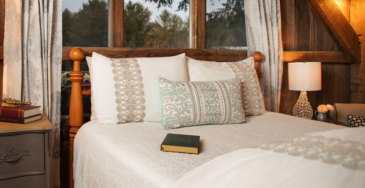 Bed with book on it next to window