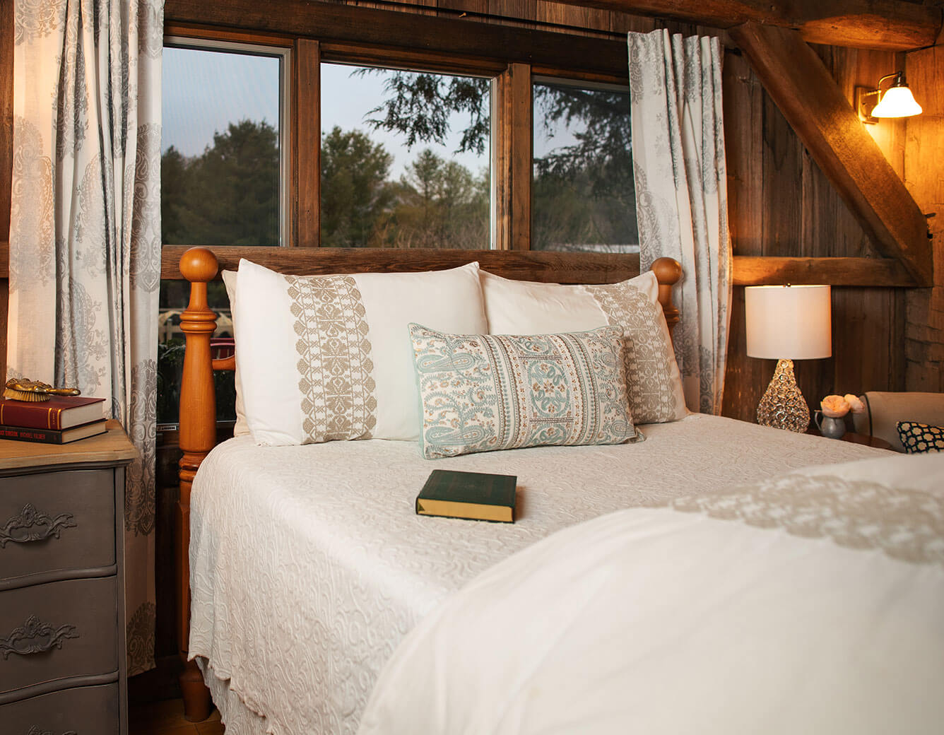 Bed with book on it next to window