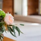 Vase of flowers in front of bed