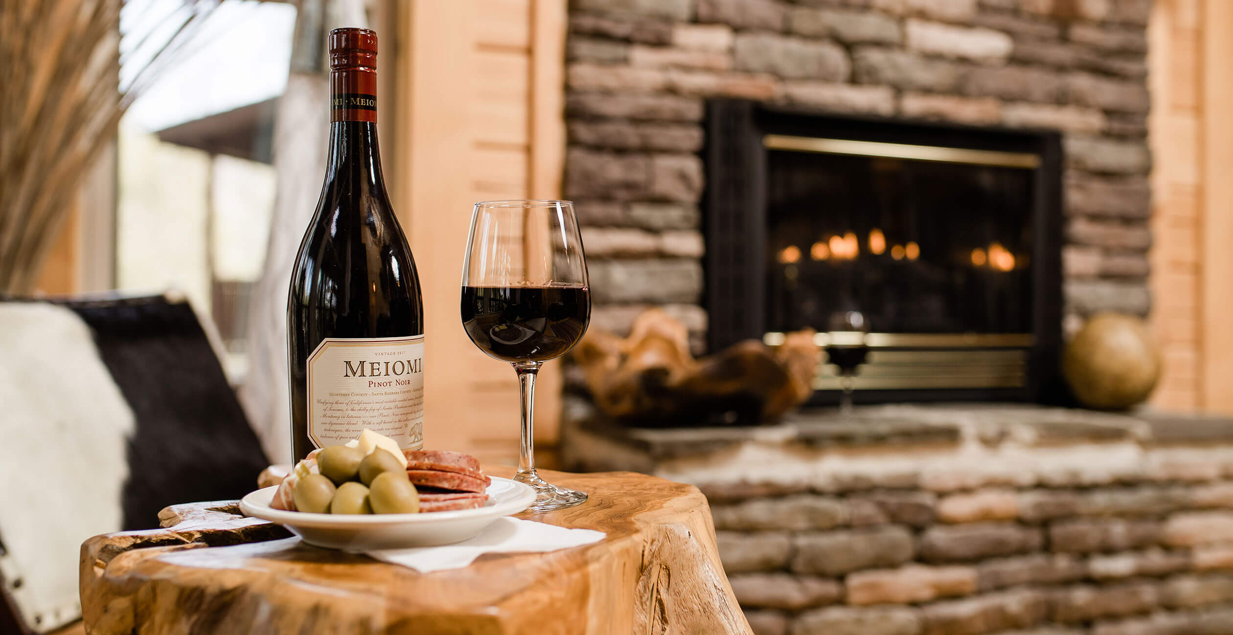 Wine and charcuterie on a small table by the fire