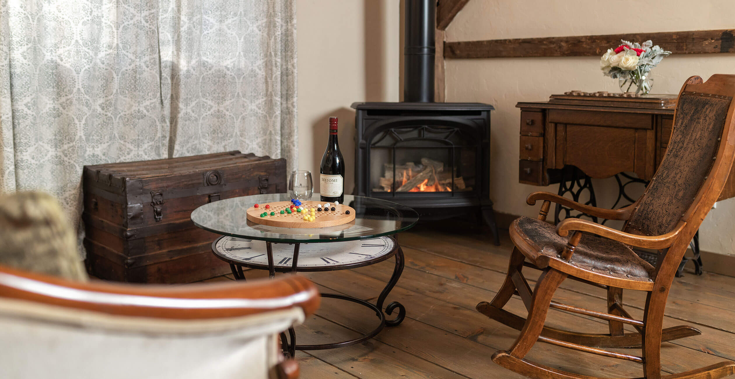 Board game and wine in sitting area with fireplace in the Woodwork Shop