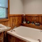 Bathtub in bathroom with wooden accents