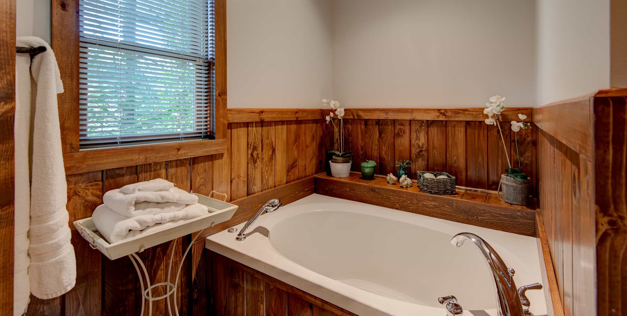 Bathtub in bathroom with wooden accents