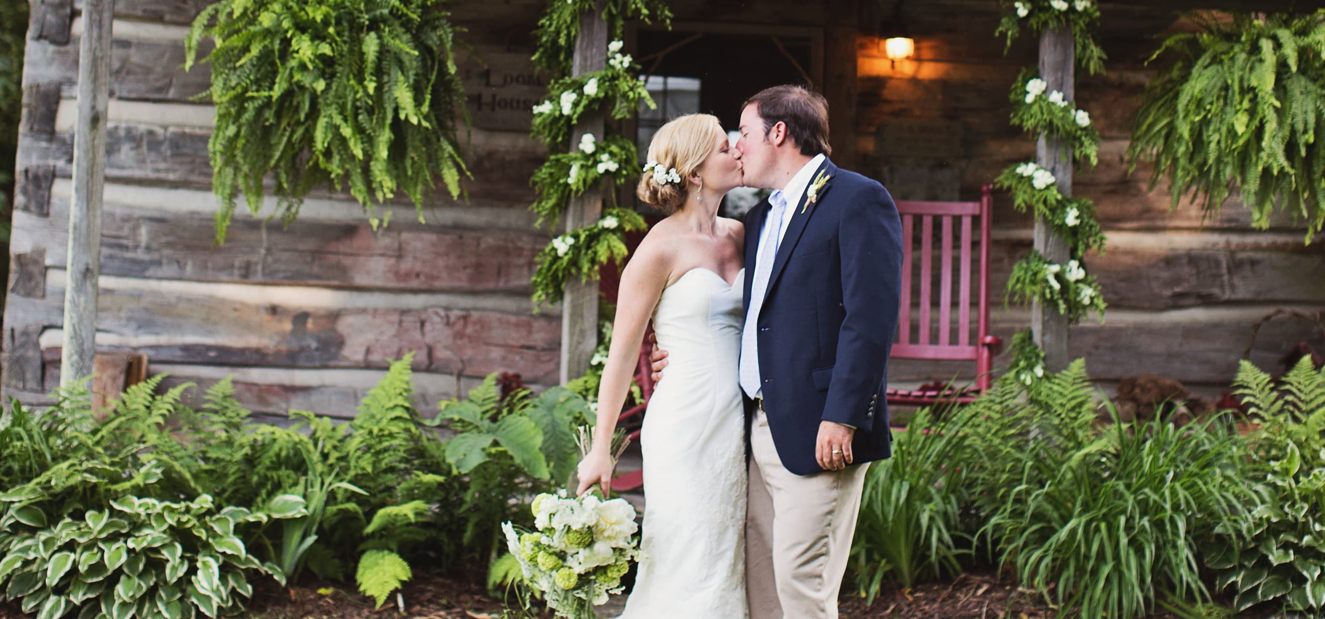 Wedding couple kissing in front of the Loom House