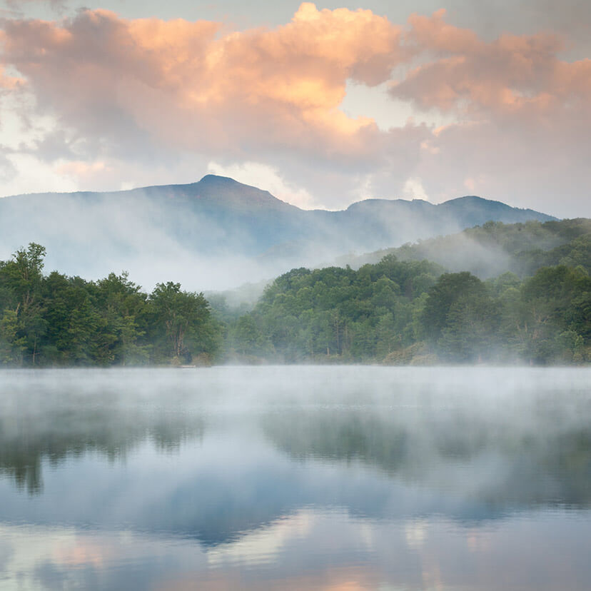 mountains reflecting in the water on a foggy morning