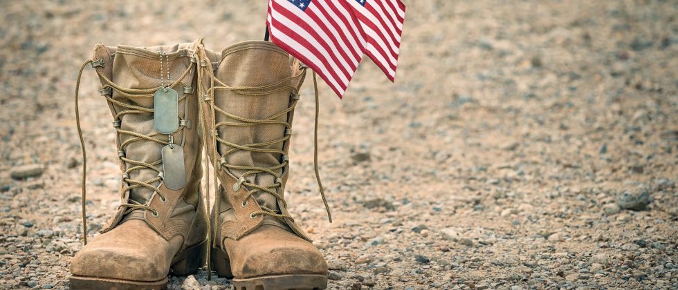 Combat boots with dog tags and American flags