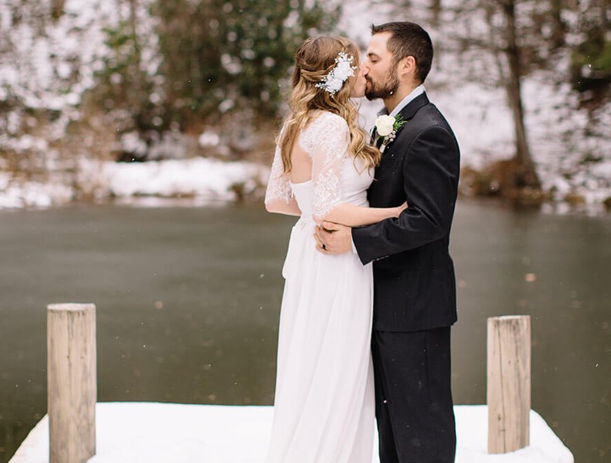Newlyweds Kissing by the Pond in Winter