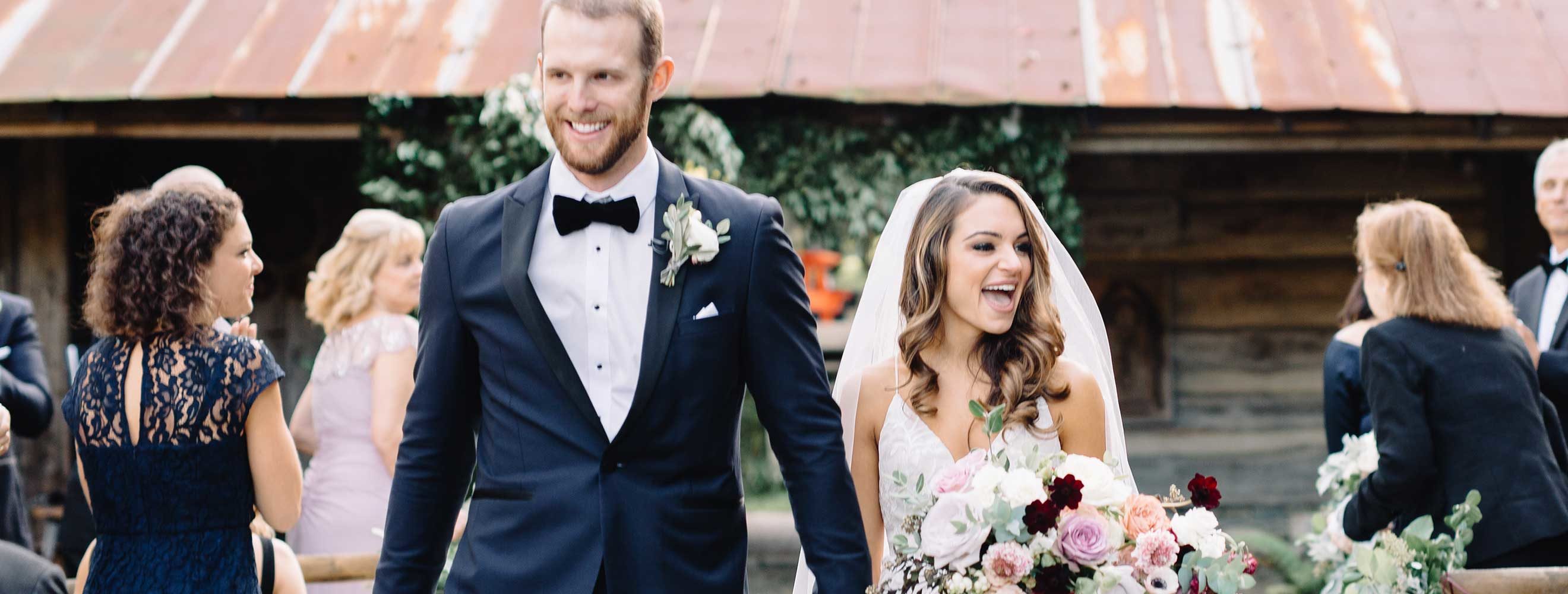 Bride and groom walking down the aisle at a barn wedding